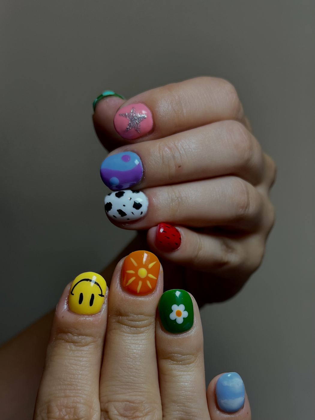 Nail art sur ongles courts : smiley, soleil, marguerite et fraise